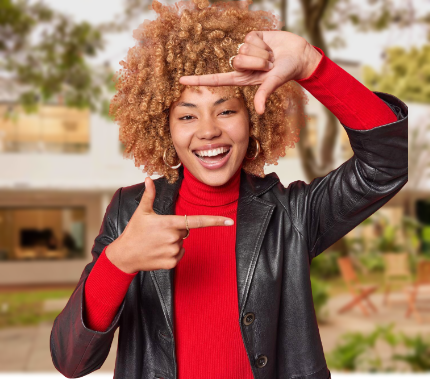 Mulher de óculos, roupas vermelhas sorrindo enquanto escreve no papel