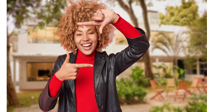 Mulher de óculos, roupas vermelhas sorrindo enquanto escreve no papel